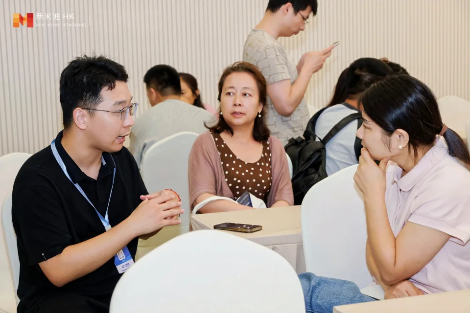 Three participants in a face-to-face conversation at an event.