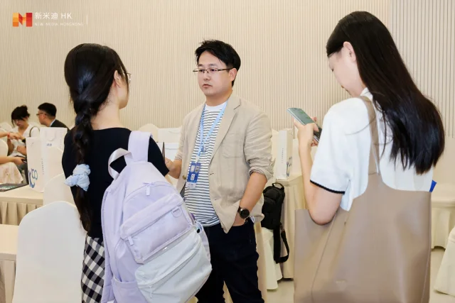 Participants standing together and talking at an event.